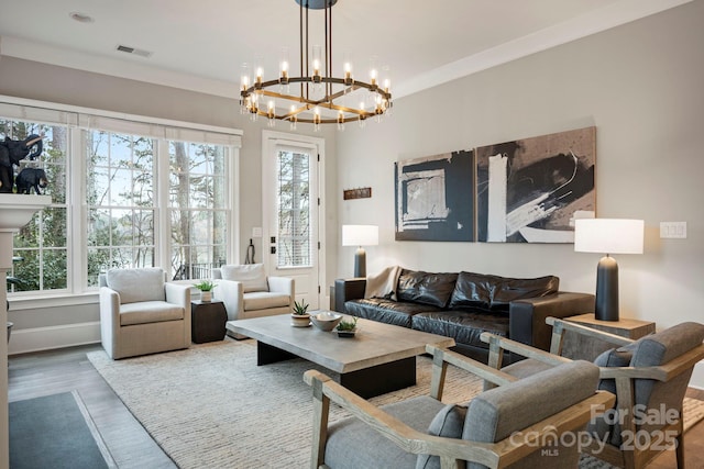 living area featuring visible vents, baseboards, wood finished floors, and crown molding