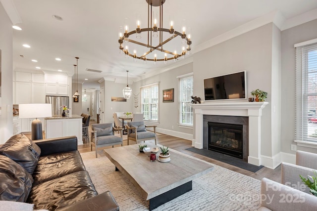 living area featuring a fireplace with flush hearth, light wood-style flooring, ornamental molding, recessed lighting, and baseboards