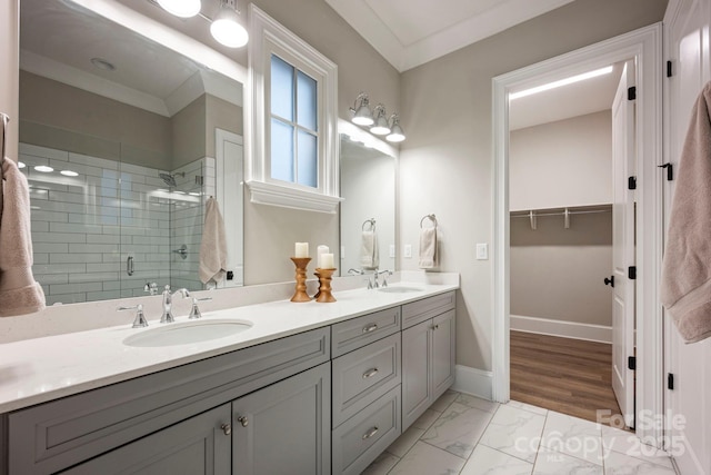 full bath with a sink, baseboards, marble finish floor, and a shower stall