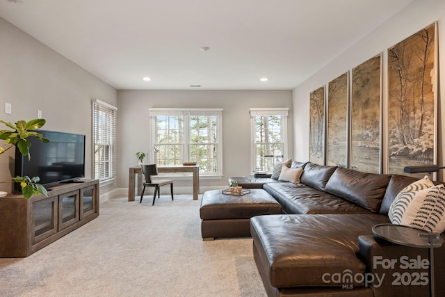 living room with recessed lighting, baseboards, and light carpet