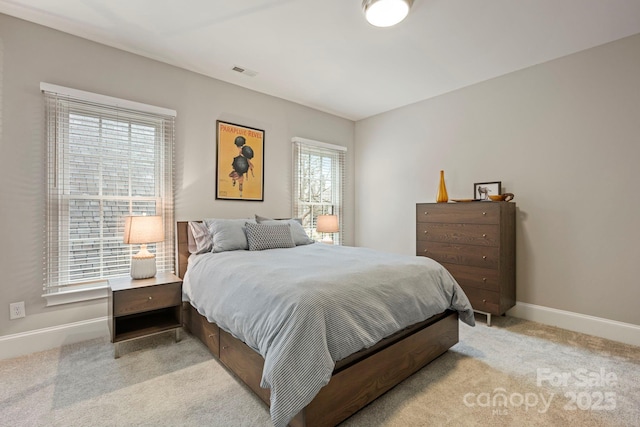 bedroom featuring baseboards, visible vents, and light carpet