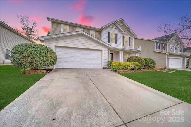 traditional home with a garage, concrete driveway, and a front lawn