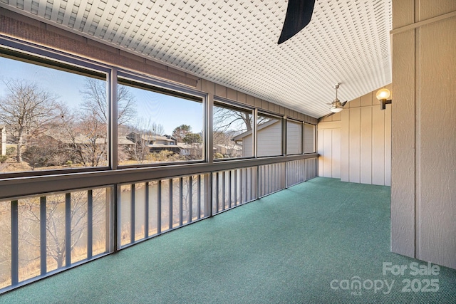 unfurnished sunroom featuring a ceiling fan