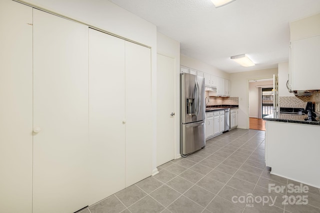 kitchen with tasteful backsplash, light tile patterned flooring, stainless steel fridge with ice dispenser, and white cabinets