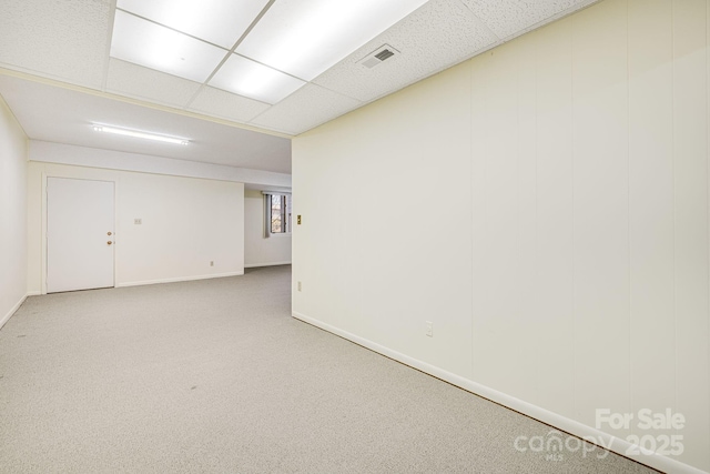 spare room with visible vents, carpet flooring, a paneled ceiling, and baseboards