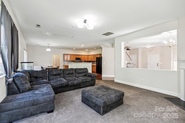 living room featuring visible vents, dark carpet, stairway, and baseboards