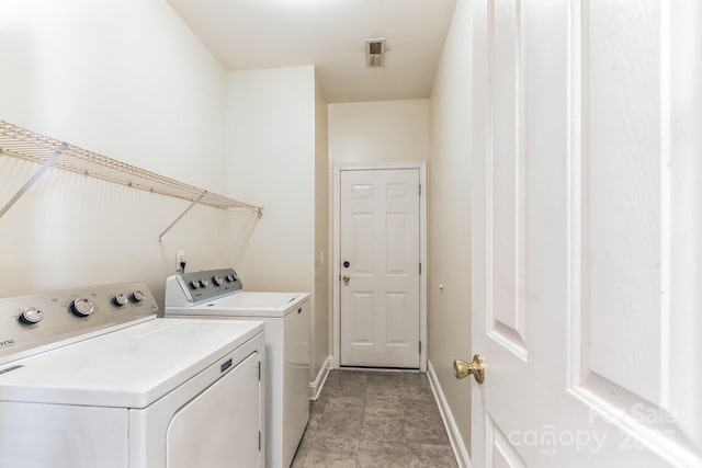 laundry area featuring laundry area, visible vents, washer and clothes dryer, and baseboards