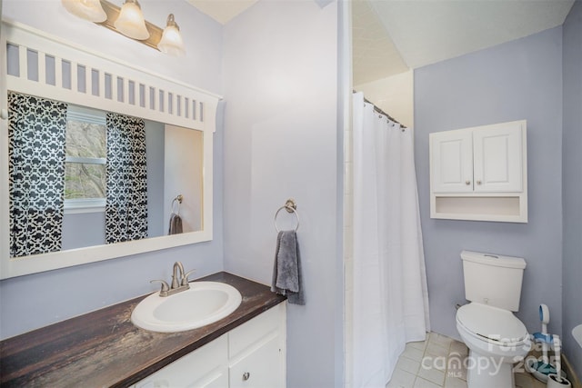 bathroom featuring a shower with curtain, vanity, toilet, and tile patterned floors