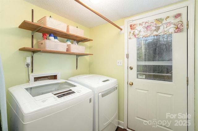 laundry area with laundry area, washer and clothes dryer, and a textured ceiling