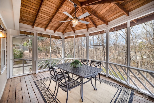 unfurnished sunroom with lofted ceiling with beams, wooden ceiling, a ceiling fan, and a healthy amount of sunlight