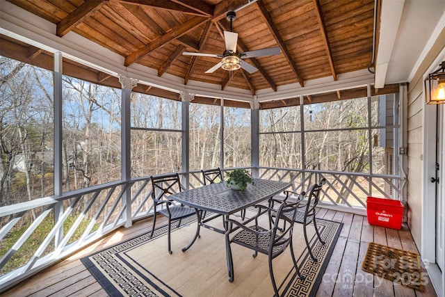 unfurnished sunroom featuring vaulted ceiling with beams, wooden ceiling, and a ceiling fan