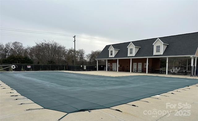 community pool with a patio and fence