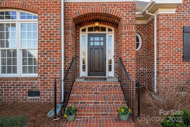 entrance to property with a shingled roof, brick siding, and crawl space