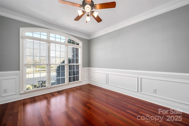 unfurnished room with crown molding, visible vents, dark wood-style flooring, and ceiling fan