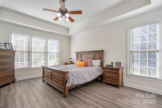 bedroom with multiple windows, wood finished floors, and crown molding