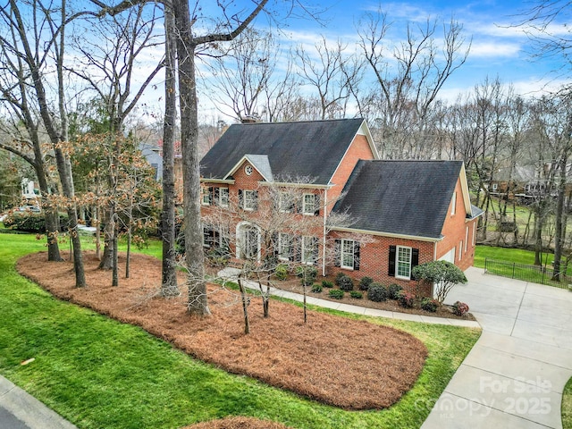 view of front of house with driveway, a front yard, a garage, and brick siding