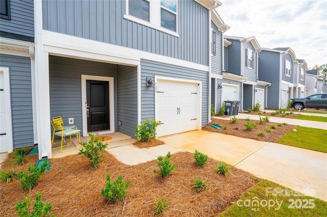 view of front of home with board and batten siding, a residential view, concrete driveway, and an attached garage