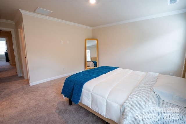 carpeted bedroom featuring visible vents, baseboards, and crown molding