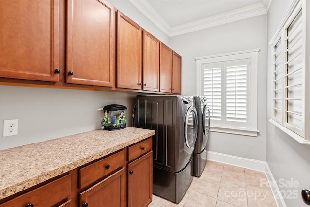 laundry area with crown molding, light tile patterned floors, cabinet space, washing machine and dryer, and baseboards