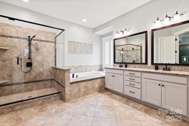 bathroom with tile patterned flooring, a sink, a bath, double vanity, and a stall shower