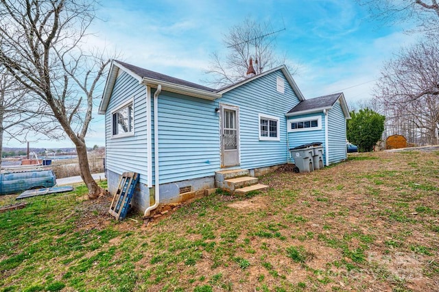 back of property with entry steps and crawl space