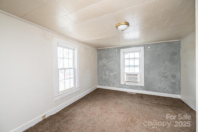 empty room with ornamental molding, carpet, cooling unit, and baseboards