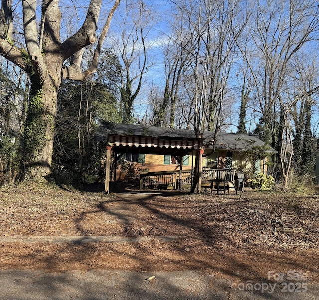 view of yard with a detached carport and a wooden deck