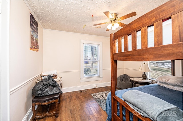 bedroom featuring baseboards, a textured ceiling, visible vents, and hardwood / wood-style floors