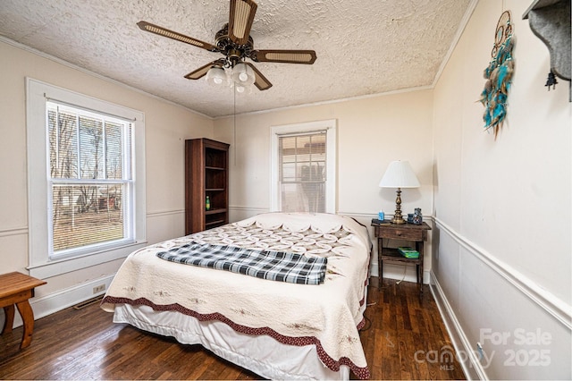 bedroom with a textured ceiling, ornamental molding, and wood finished floors