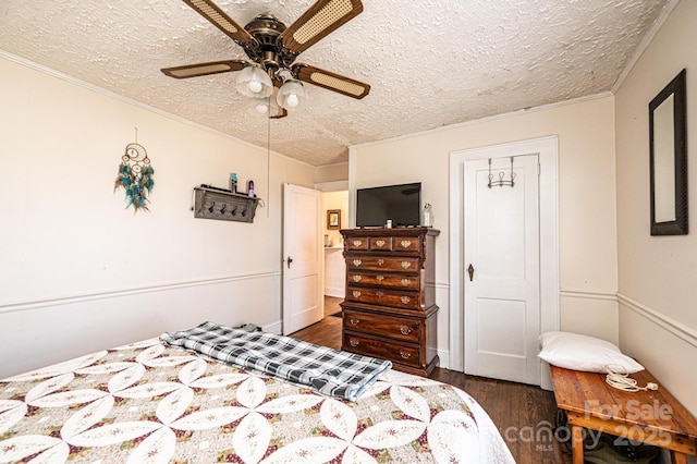 bedroom with a textured ceiling, wood finished floors, a ceiling fan, and crown molding