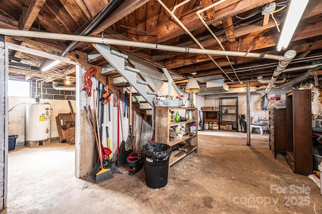 unfinished below grade area featuring concrete block wall and water heater