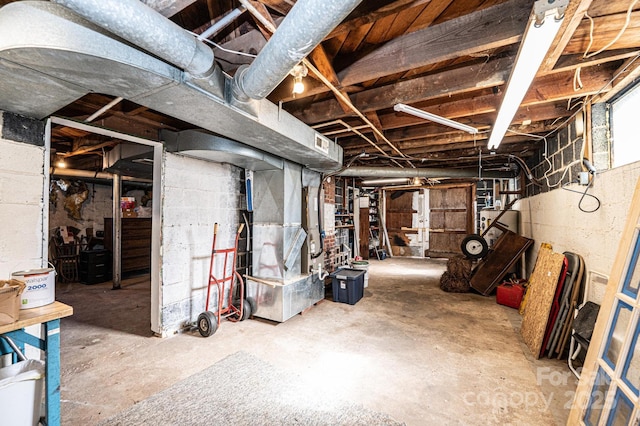 unfinished basement featuring water heater and heating unit