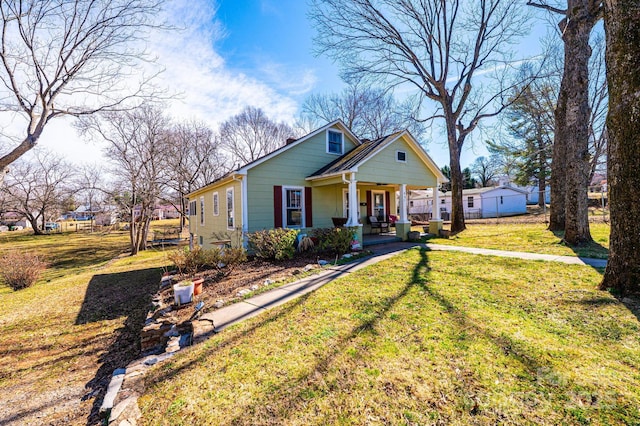 bungalow with covered porch and a front yard