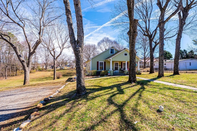 view of front of house featuring a porch, a front yard, and fence