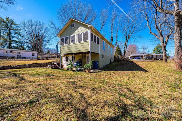 back of property featuring a lawn and a sunroom