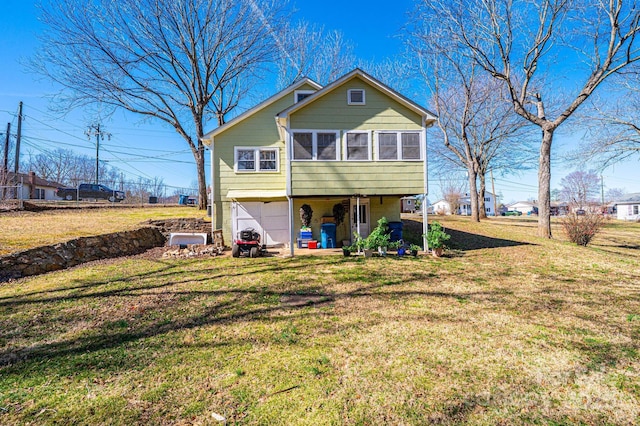 view of front of home with a garage, driveway, a front yard, and a sunroom