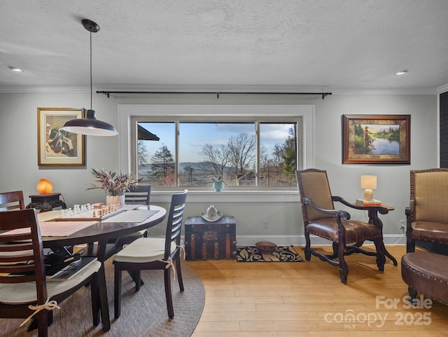 dining area featuring crown molding, wood finished floors, a wealth of natural light, and a textured ceiling