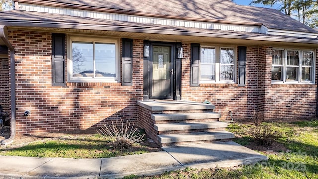 doorway to property featuring brick siding