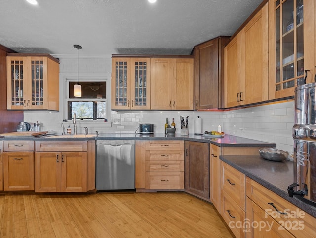 kitchen featuring decorative light fixtures, dishwasher, glass insert cabinets, and light wood-type flooring