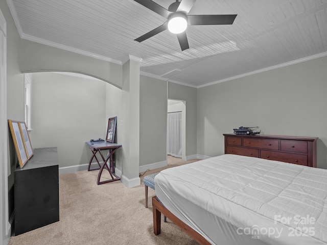 bedroom with arched walkways, crown molding, baseboards, light colored carpet, and ceiling fan