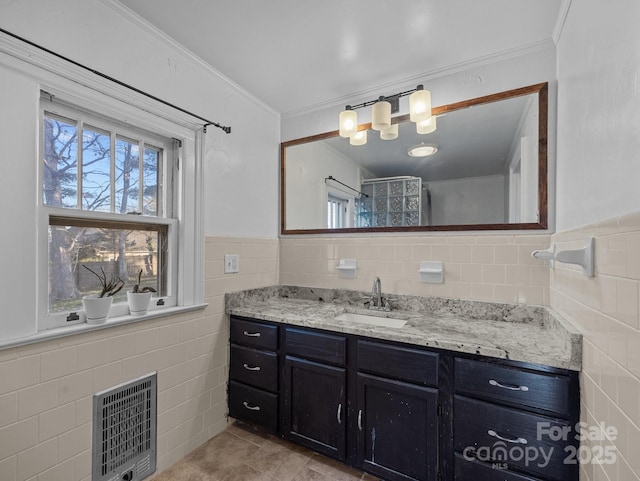 full bathroom with ornamental molding, heating unit, tile walls, a shower, and vanity