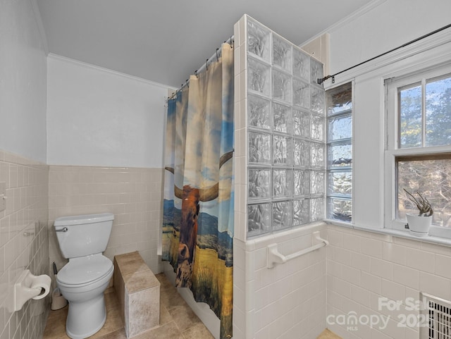 bathroom featuring a healthy amount of sunlight, tile walls, and a shower with curtain