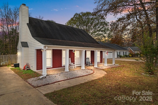 view of front of property with a garage, fence, a chimney, and a shingled roof