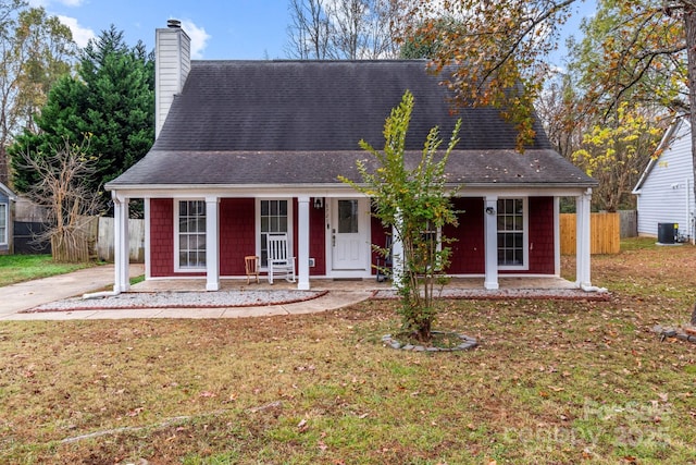 view of front of home with covered porch, a front lawn, and fence