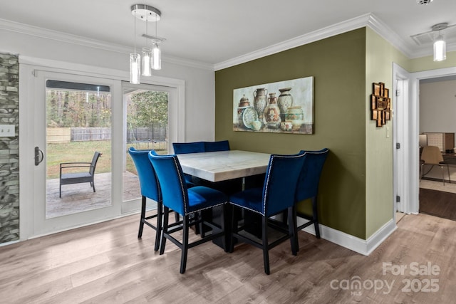 dining area featuring baseboards, ornamental molding, and wood finished floors