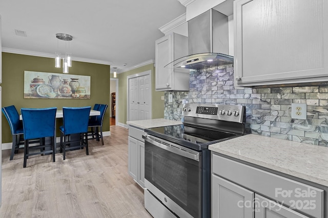 kitchen featuring tasteful backsplash, wall chimney exhaust hood, stainless steel electric stove, crown molding, and light wood-style floors