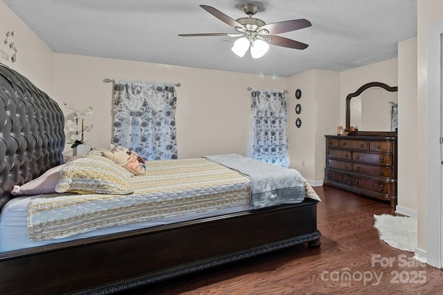 bedroom featuring a textured ceiling, ceiling fan, wood finished floors, and baseboards