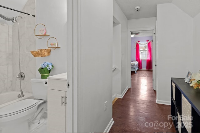 hallway featuring dark wood-style floors, baseboards, and a textured ceiling