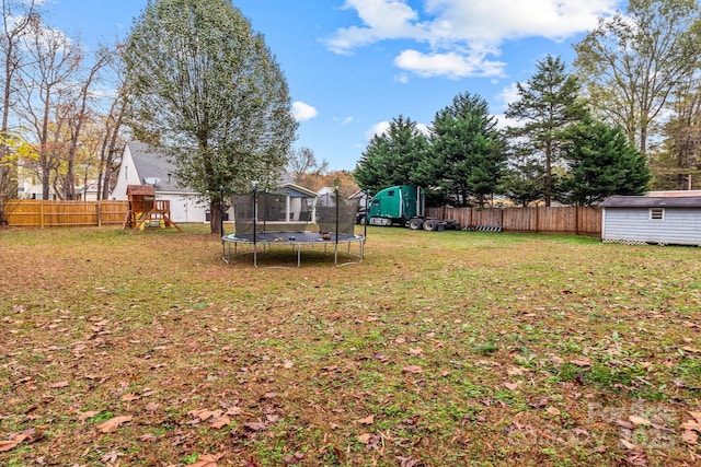 view of yard with a trampoline, a playground, an outdoor structure, and a shed