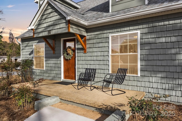 exterior entry at dusk with a shingled roof